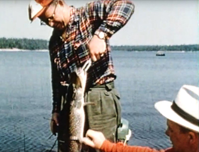 pcheur tenant un poisson pendant qu'un autre homme le touche